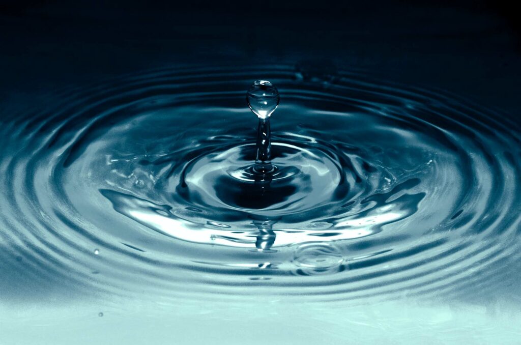 water drop into a pool of blue water
